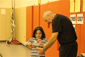 Teacher showing student how to use heart rate monitor 