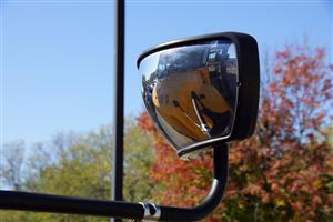 A rearview mirror of a yellow school bus 