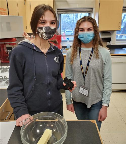 Two students holding a cookie cutter 