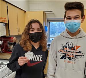 Bartlett High School students showing off a cookie cutter 