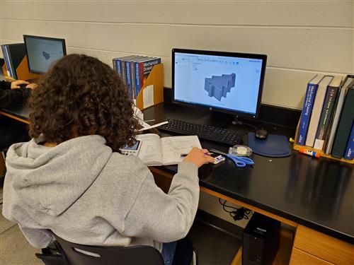 Student at a computer sketching a Christmas tree