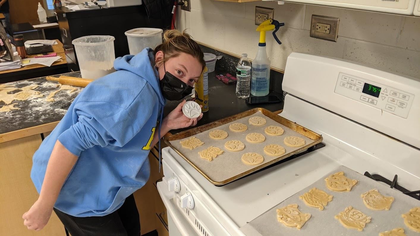 Student shows off mold used to make cookies 