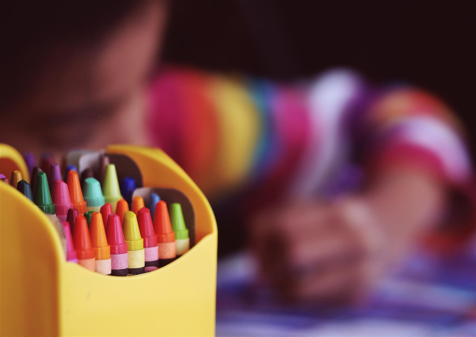  Child coloring with crayons with the box in the foreground