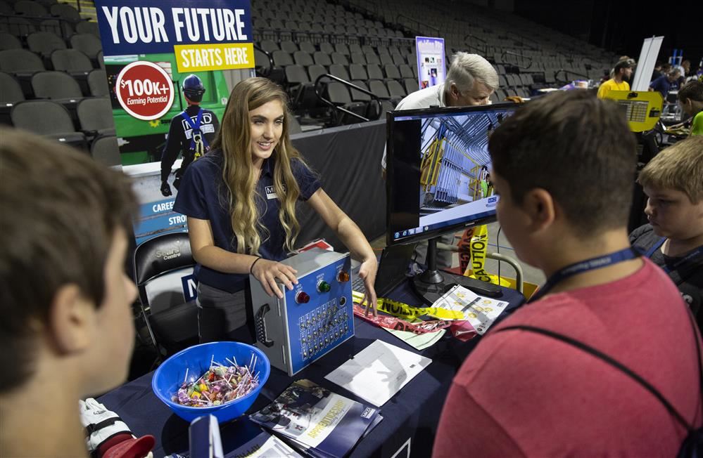  Exhibitor talking with students