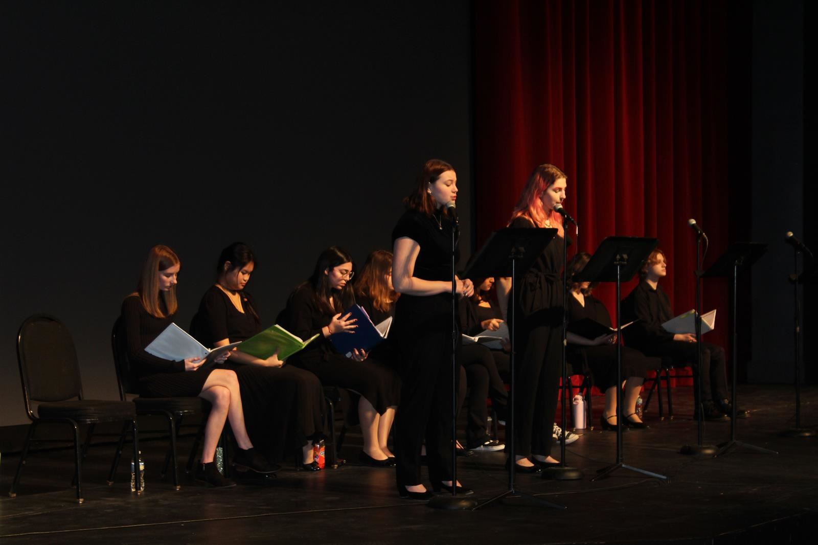 students on stage reading play 