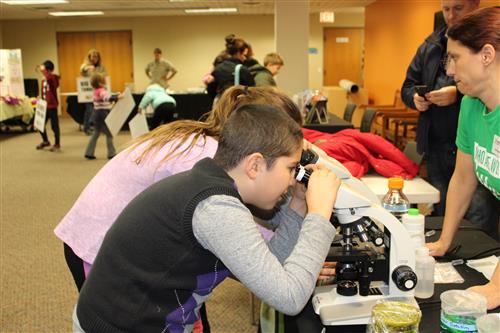 Students look in a microscope at the Bartlett Public Library  