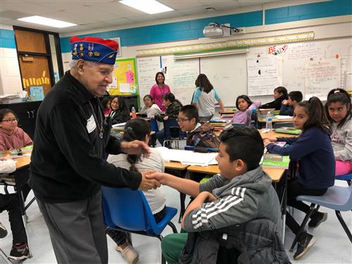 Johnny Vargas shakes a student's hand at Garfield Elementary in Elgin. 