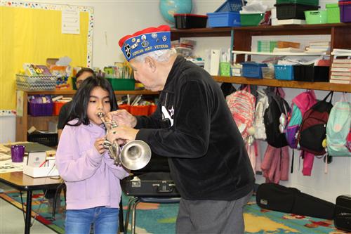 Johnny Vargas shows a student how to play the trumpet. 