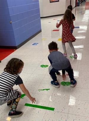 Children use green sensory path in hallway 